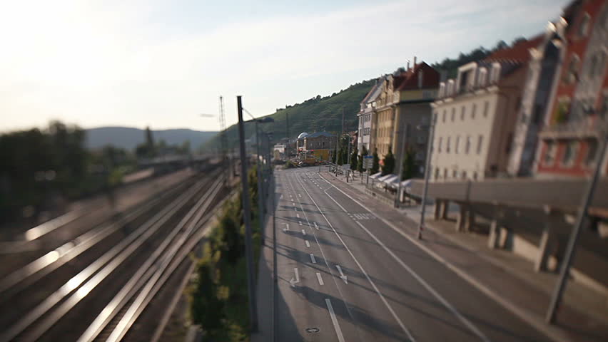 a tilt and shift shot of traffic in city with rails and streets