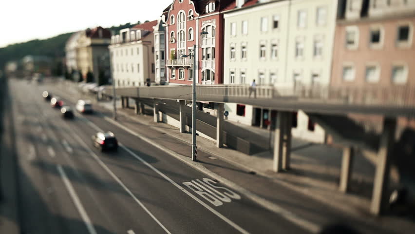 a tilt and shift shot of traffic in city with bridge and street