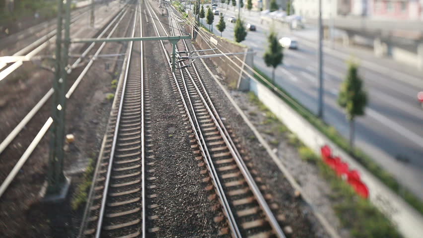a tilt and shift shot of traffic in city with rails and streets