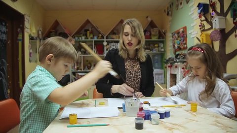 Children paint together with adults