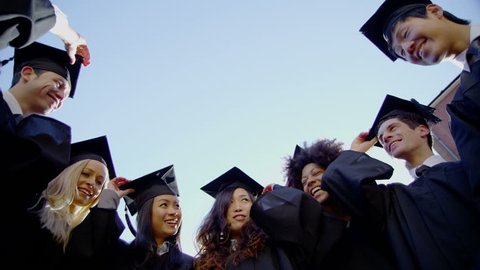 4k / Ultra HD version Graduation caps are tossed into the air by a happy multi-ethnic group of friends on a bright sunny day. In slow motion. Low angle. Shot on RED Epic