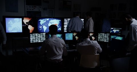 4k / Ultra HD version Time lapse clip of a team of male security personnel who are manning the stations within a busy system control room. It could be a power station or police/army control facility. 