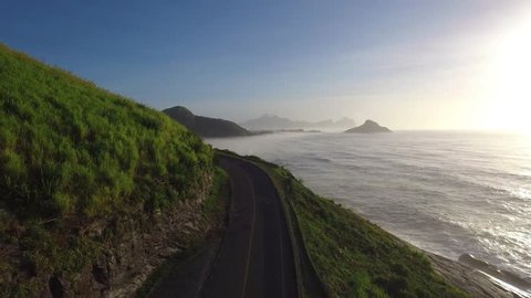 Drone view making a travelling over a road along the Brazilian sea coast in Rio de Janeiro during a Sunny foggy day on summer 2016.
