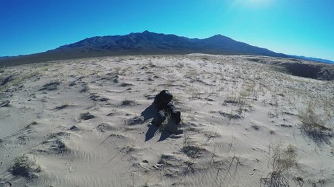 KELSO, CA/USA - January 15, 2016: Zoom in shot of a body of a man lying prone on the sand in the Mojave Desert. Dehydration and sun exposure is a danger in arid climates. 