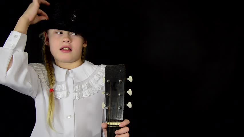 girl measures the hat and holding a guitar in a white dress on a black background HD