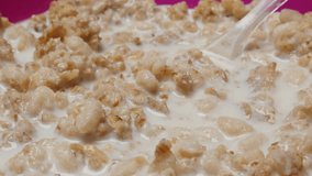 Spoon mixed cereals with milk high energy morning food 4K 30fps 2160p UHD footage - Rice and wheat cereal filled up with milk in plastic bowl 4K 3840X2160 UltraHD video
