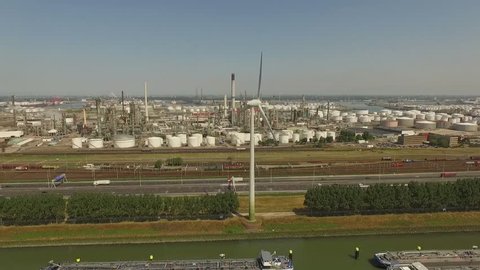 Aerial footage from the Botlek Europoort Rotterdam. Modern windmills, a busy highway and a large petrochemical plant. All shot on a sunny day during the summer.