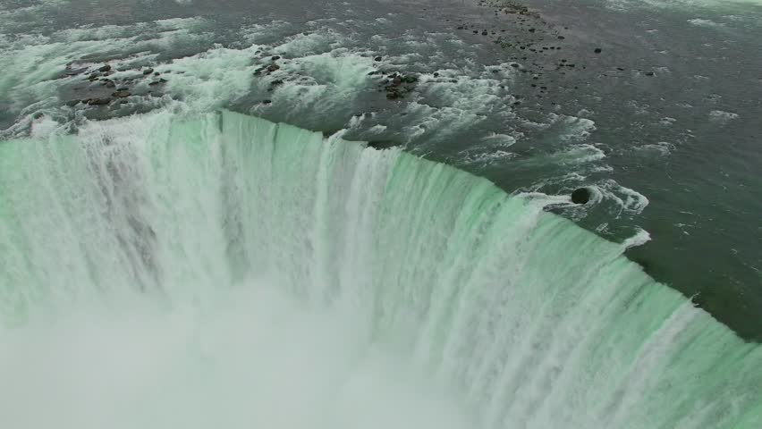 Aerial shots above Niagara Falls in the morning light. Drone flying above the mighty Niagara Falls on the Canadian side for sunrise view. Flying over Horse Shoe Falls and the Niagara River.