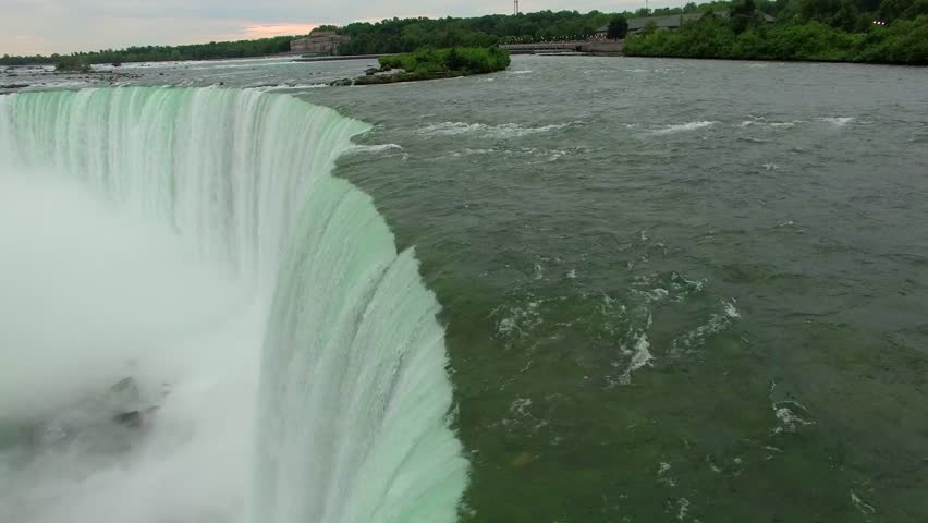 Aerial shots above Niagara Falls in the morning light. Drone flying above the mighty Niagara Falls on the Canadian side for sunrise view. Flying over Horse Shoe Falls and the Niagara River.