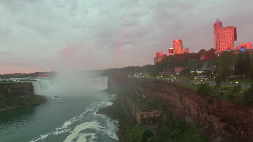 Aerial shots above Niagara Falls in the morning light. Drone flying above the mighty Niagara Falls on the Canadian side for sunrise view. Flying over Horse Shoe Falls and the Niagara River.