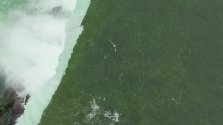 Aerial shots above Niagara Falls in the morning light. Drone flying above the mighty Niagara Falls on the Canadian side for sunrise view. Flying over Horse Shoe Falls and the Niagara River.