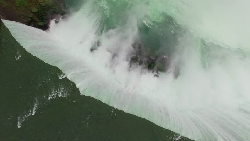 Aerial shots above Niagara Falls in the morning light. Drone flying above the mighty Niagara Falls on the Canadian side for sunrise view. Flying over Horse Shoe Falls and the Niagara River.