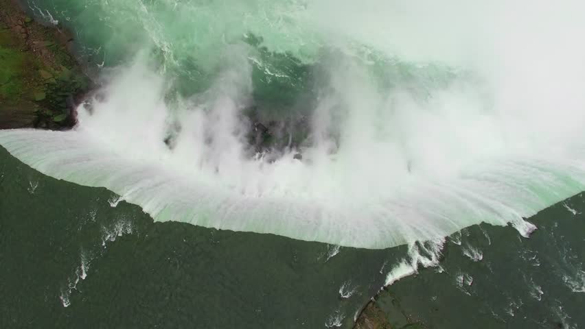 Aerial shots above Niagara Falls in the morning light. Drone flying above the mighty Niagara Falls on the Canadian side for sunrise view. Flying over Horse Shoe Falls and the Niagara River.