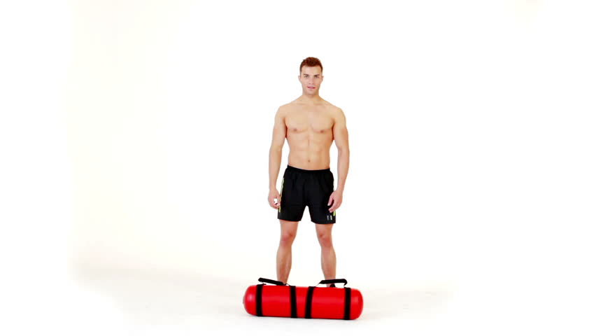 Handsome muscular man exercising with water bag on white background