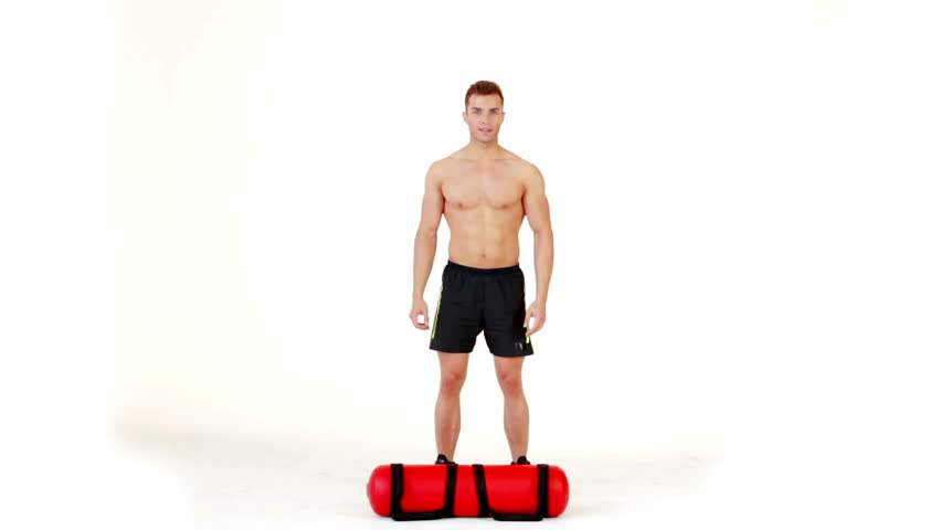 Handsome muscular man exercising with water bag on white background