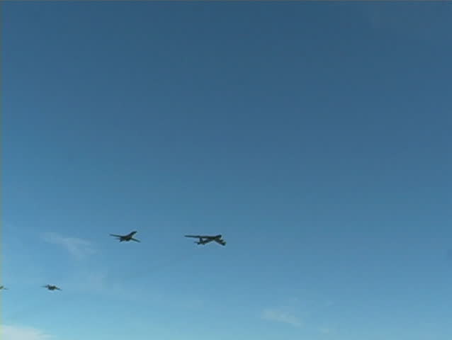 Large cargo airplane and bombers fly by. 