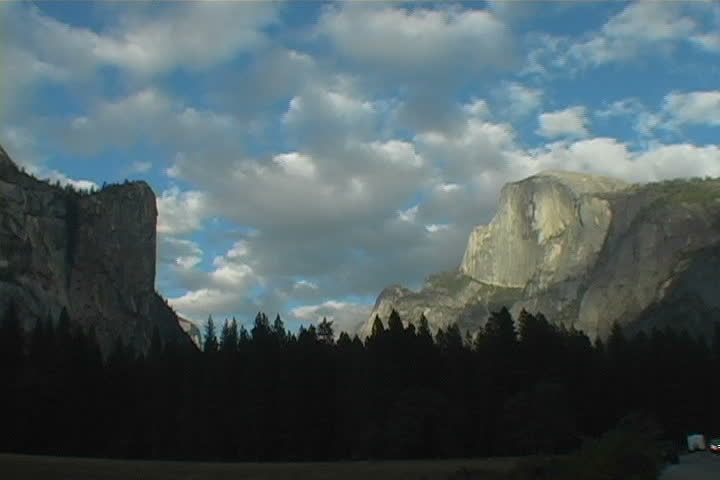 Half Dome in Yosemite with clouds racing by at sunset.