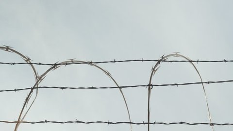 an airplane taking off behind barb wire border
