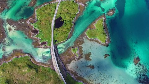 Aerial top down view of road connecting small islands slowly revealing bridges leading to village on Lofoten islands in Norway. Aerial 4k Ultra HD.