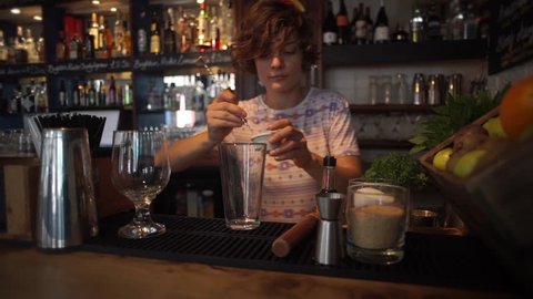 This video is a 'how to' video, 1 minute long cut, bartender is showing her process of her own bloody mary cocktail recipe at the counter of the bar with amazing garnish on it.