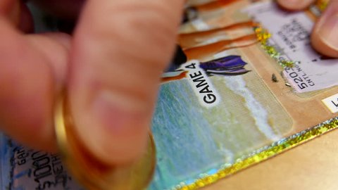 Coquitlam, BC, Canada - January 24, 2016 : Close up woman scratching set for life lottery ticket with 4k resolution