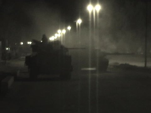 An Abrams tank fires into an Iraqi village.