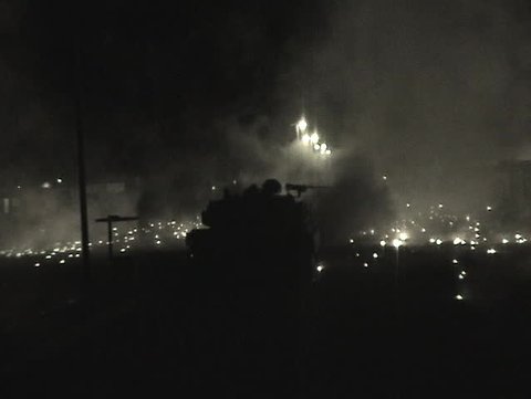 Abrams tanks fire into an Iraqi village.