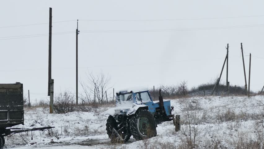 Tractor  slips stuck in snow on road winter