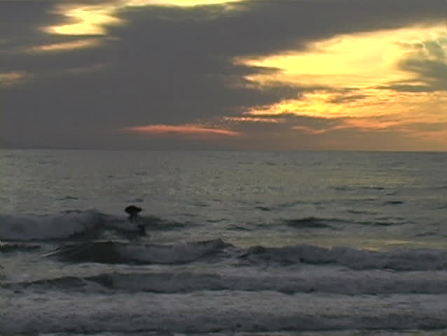 A surfer catches the last wave of the day.