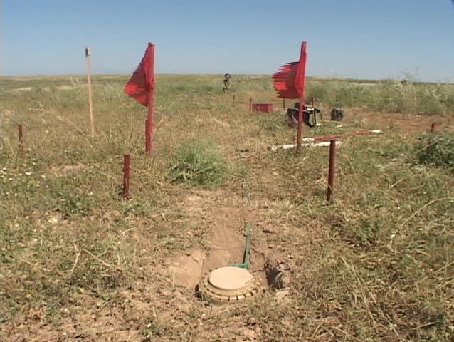 A land mine removal expert pulls on a land mine in Iraq.