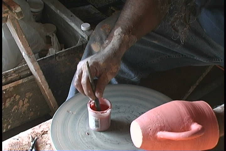 An artist paints a vase.