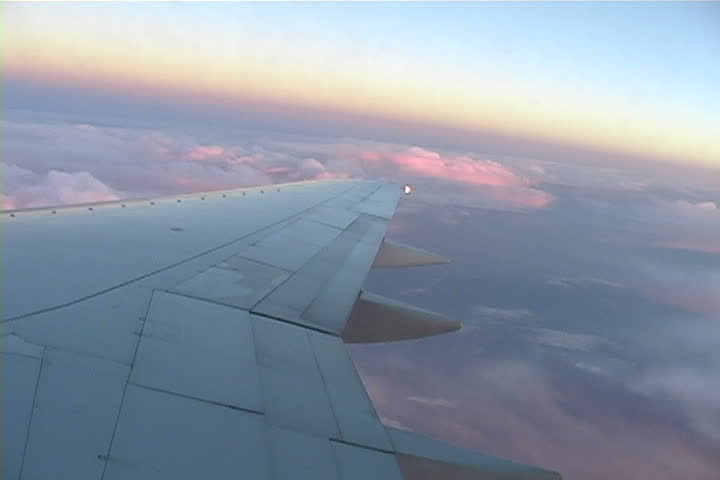 A view from a window seat above the wing of a airplane.