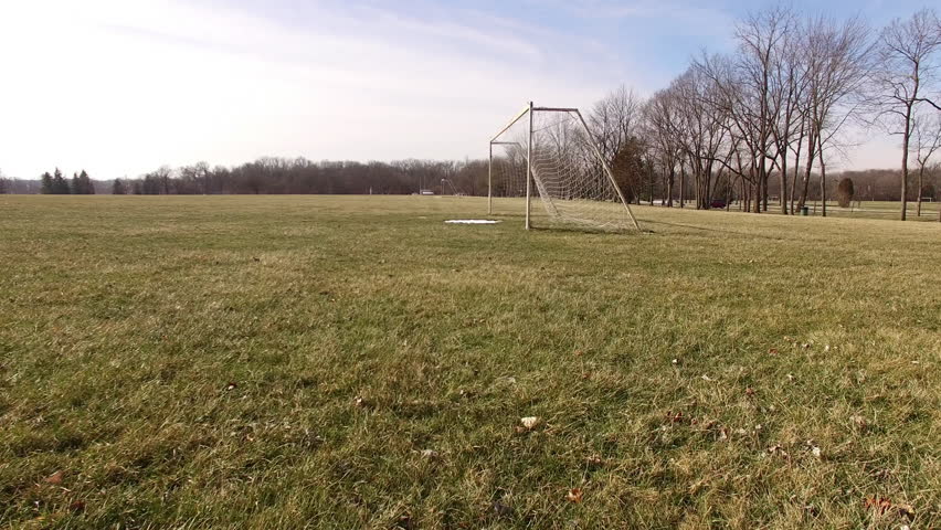 Soccer goal in winter with snow on field aerial shot 4k