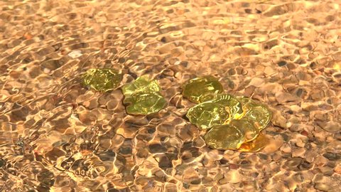 Gold coins in a river bed, filmed in 4k video.