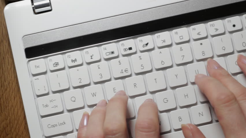 Tracking shot of woman using laptop keyboard
