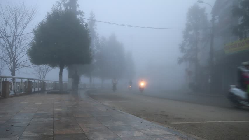 Peple driving and walking down the street in the heavy mist (the fog) and cool in SAPA, VIETNAM, City of Fog