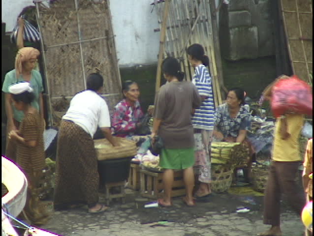 People walk on a narrow street of a small village.
