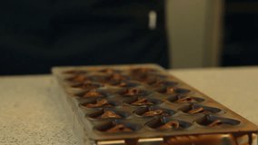 Close-up of female hands making chocolate candies