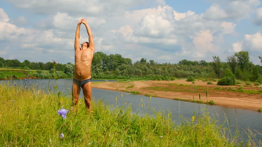 man with hands up on the river, summer