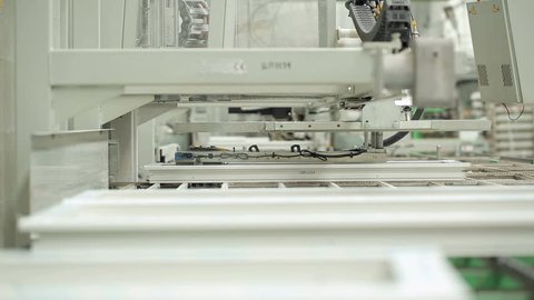 Line production of plastic windows. Plastic window frames move along the production line. Windows whites in a clean room.