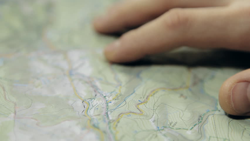 HD Dolly shot of men's finger planning hiking trip on a map with compass. Shot with motorized dolly and Canon 5Dmk2.