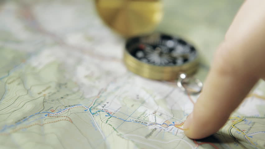 HD Dolly shot of men's finger planning hiking trip on a map with compass. Shot with motorized dolly and Canon 5Dmk2.