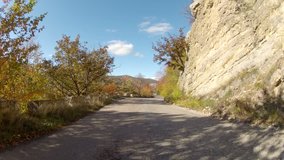 The old road in the mountains, with the rock wall on the roadside, video with Go Pro