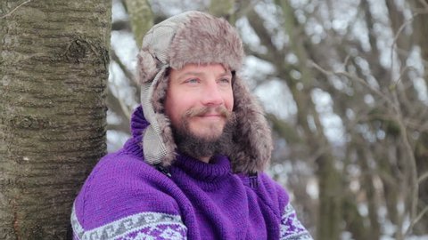 Portrait of a young handsome man with a beard. A bearded man in the winter woods. Healthy young bearded man in nature. 
