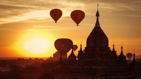 Time lapse of balloons flying at sunrise over ancient Buddhist Temple silhouette at Bagan. Myanmar (Burma) travel landscape and destinations