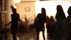  Silhouettes of people dancing. Beautiful thin girls are dancing cheerfully. Blurred full hd video clip. Anonymous persons on dance-floor. Real time video footage.