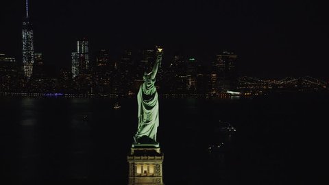 4k / Ultra HD version Helicopter aerial night view of Statue of Liberty, New York City State. Flying overhead. Her torch burns bright. Famous United States tourism attraction. Shot on RED Epic