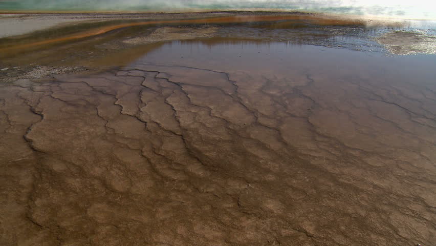 Cracked mud and Grand Prismatic Spring in Yellowstone National Park