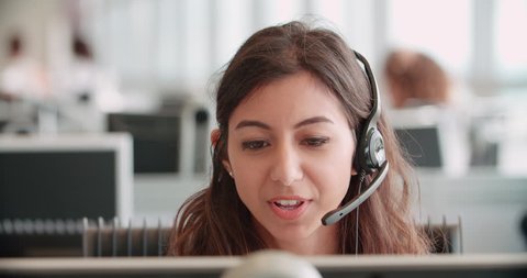 Young woman working in a call center using a headset Adlı Stok Video