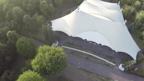 Aerial video of the Cirque/circus De Soleil tent in Poland. Deep woods, green environment. Aerial footage vertical point of view. Dron footage quality best.